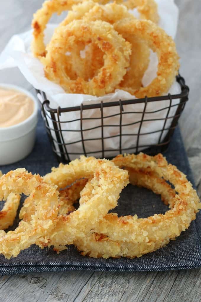 Onion rings in a basket with dipping sauce