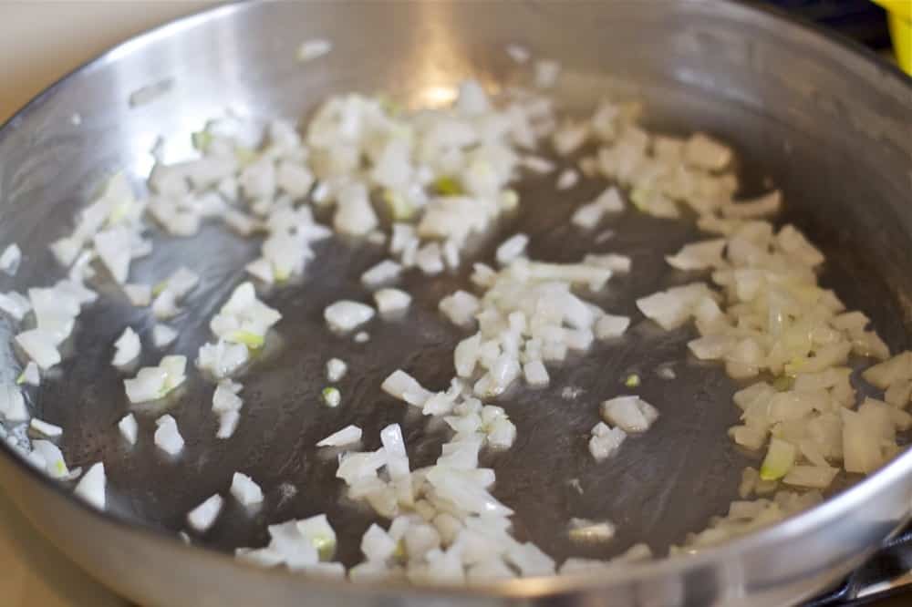 Onions Cooking in Stainless Steel Pan on Stovetop