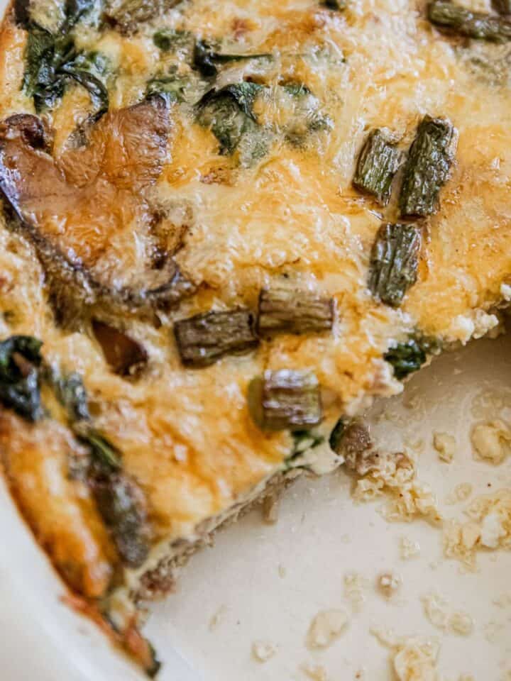Delicious sausage and asparagus frittata with melted cheese and fresh greens. Perfect for breakfast.