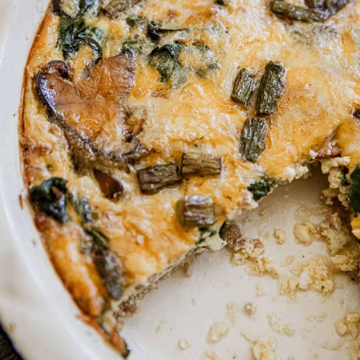 Delicious sausage and asparagus frittata with melted cheese and fresh greens. Perfect for breakfast.