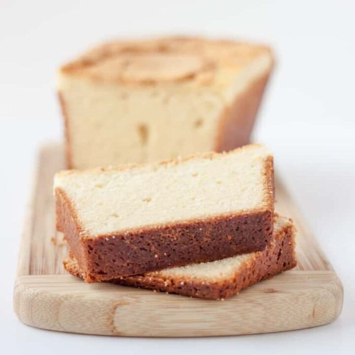 Cream cheese pound cake with a marbled swirl, sliced on a wooden board.