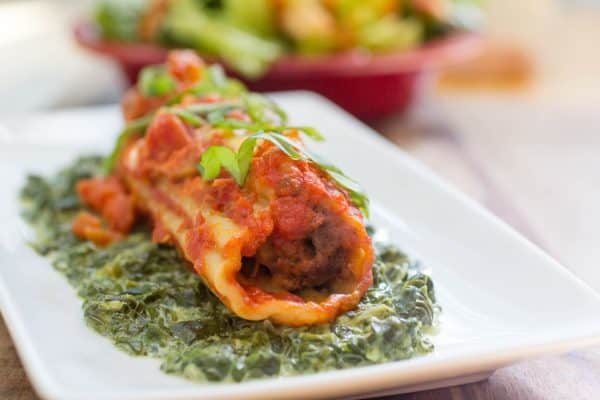Amazing meatball stuffed manicotti on a bed of creamed spinach.