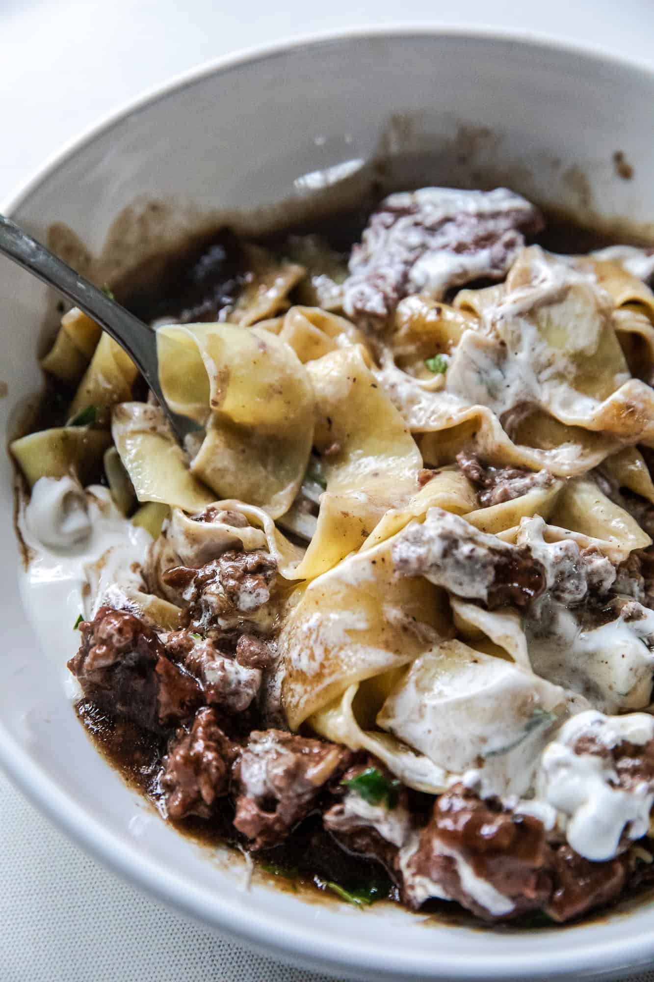 Delicious ground beef stroganoff served in a white bowl with creamy sauce.