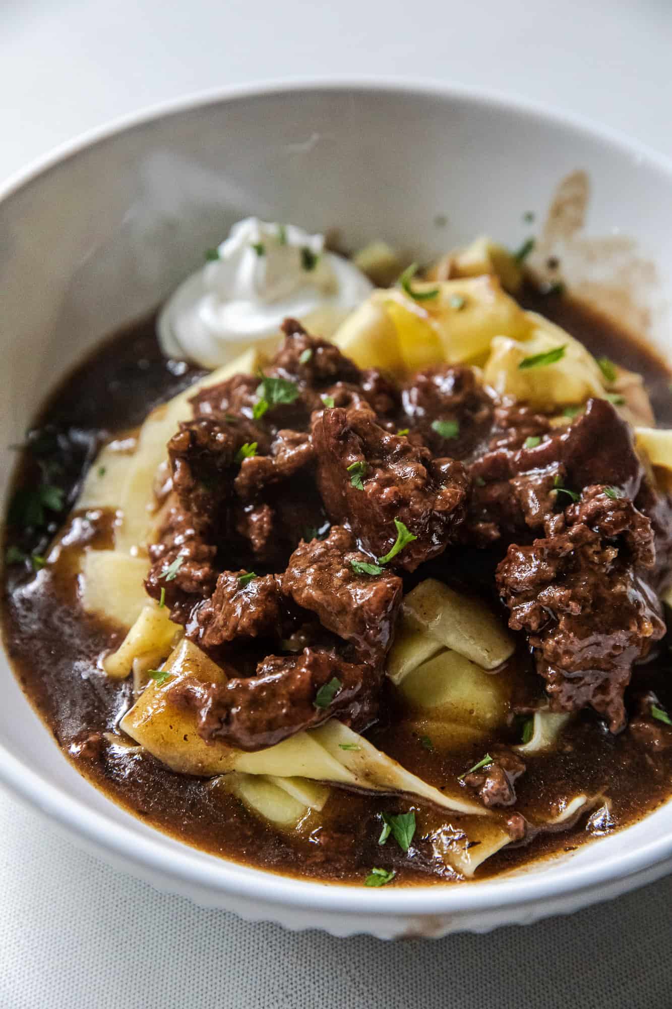 Delicious ground beef stroganoff with noodles and rich sauce in a white bowl.