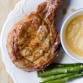 Traeger Grilled Pork Chops on a plate with asparagus