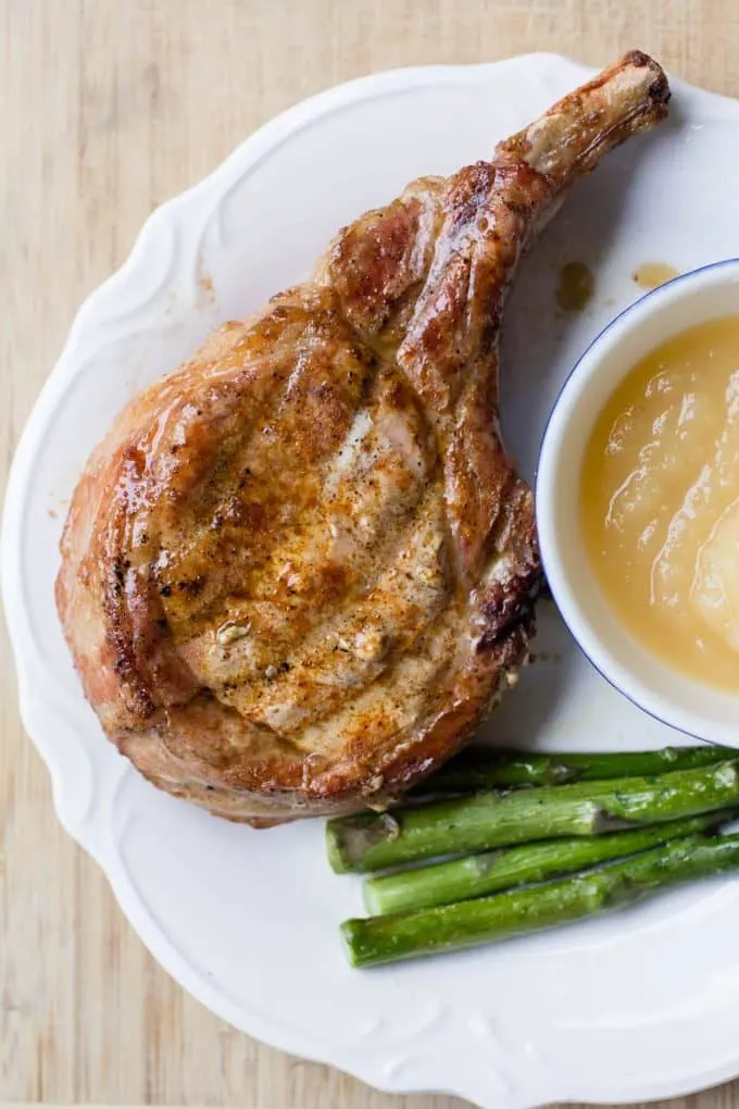 Traeger Grilled Pork Chops on a plate with asparagus