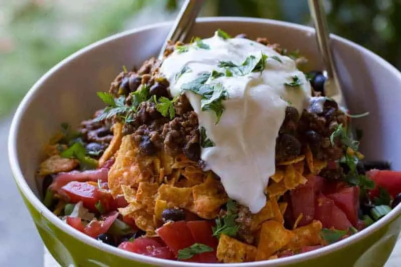 Doritos taco salad topped with cheese and lettuce.