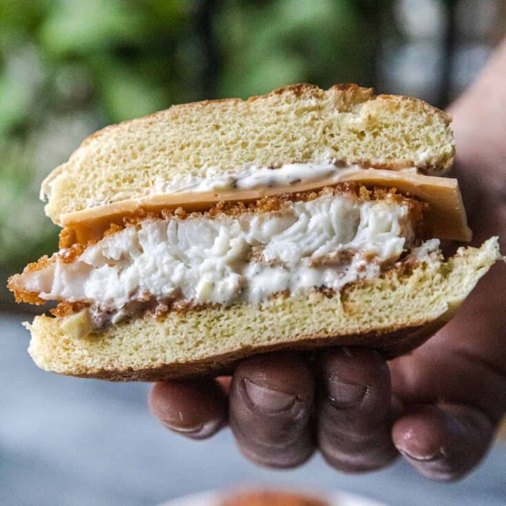 Crispy panko-coated fish sandwich with creamy filling and toasted bun.