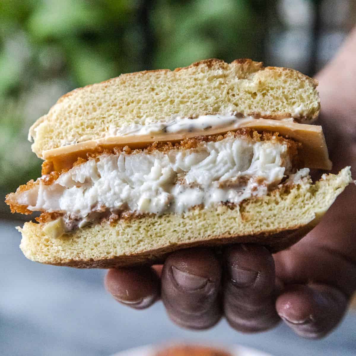 Crispy panko-coated fish sandwich with creamy filling and toasted bun.