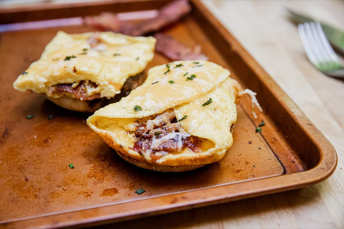 Baked potatoes stuffed with cheese and bacon on a wooden tray.