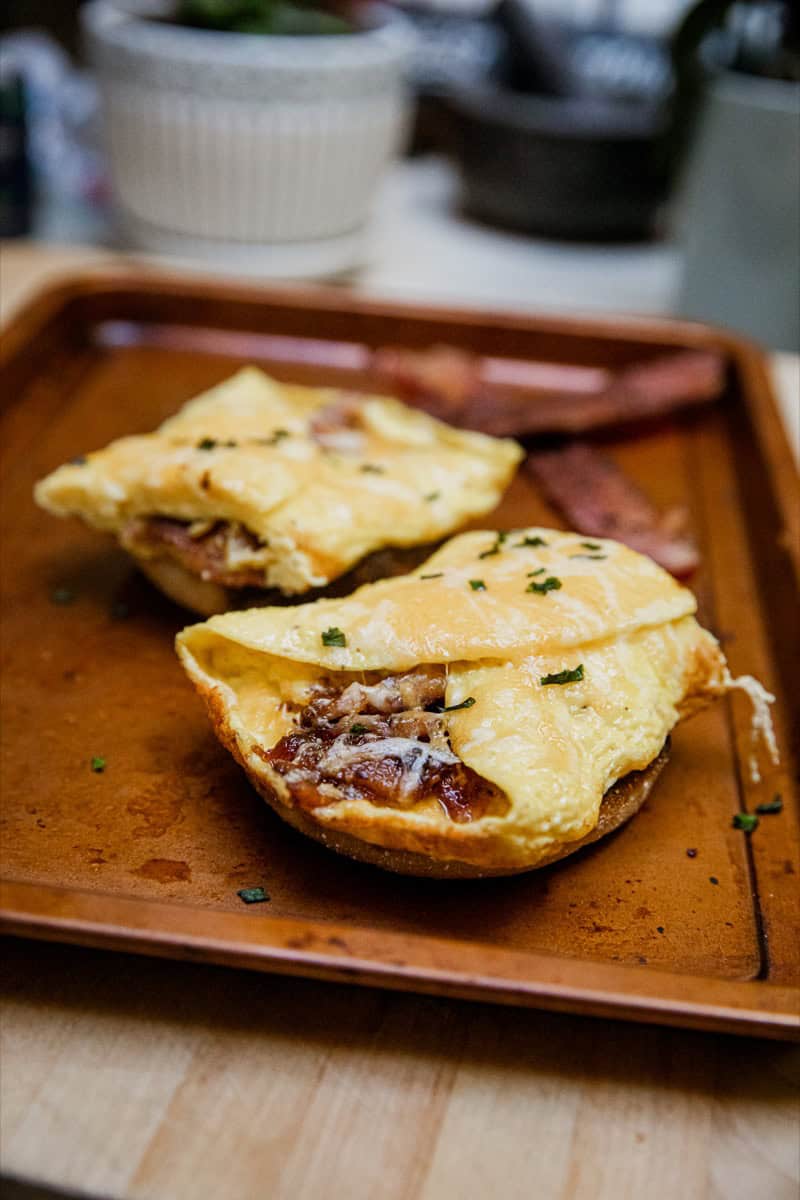 Delicious scrambled eggs with bacon served on a wooden plate for breakfast.