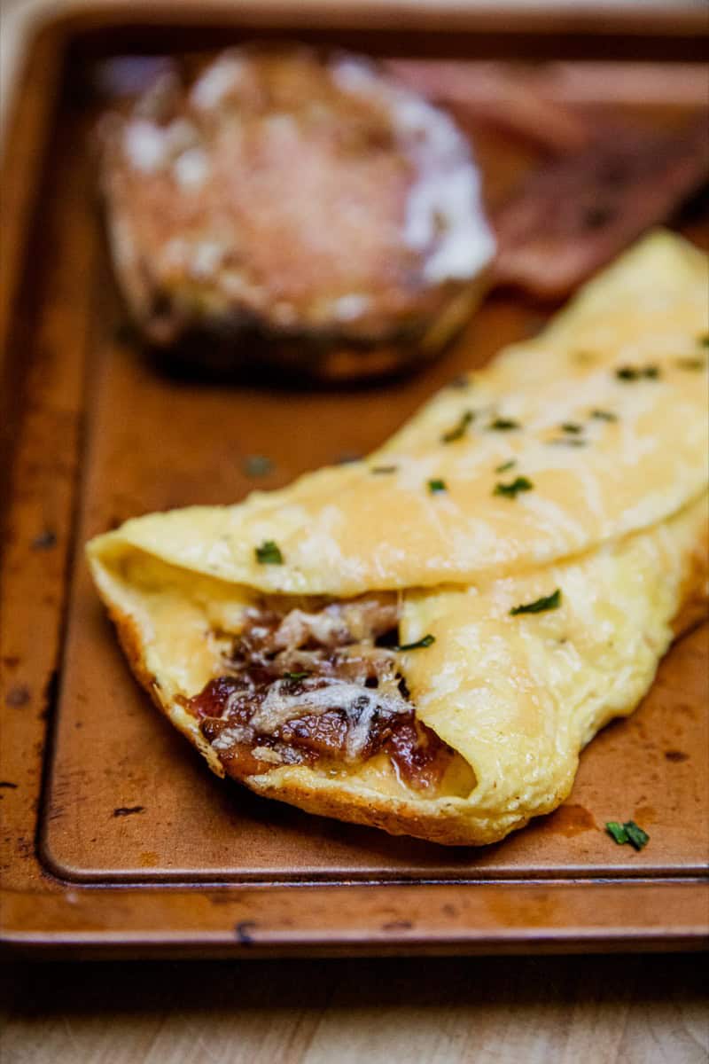Delicious homemade omelette filled with mushrooms, herbs, and cheese, served on a wooden tray for a.