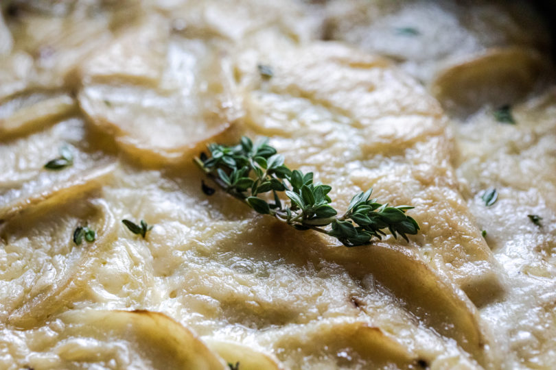 Traeger Scalloped Potatoes close up showing thyme on top