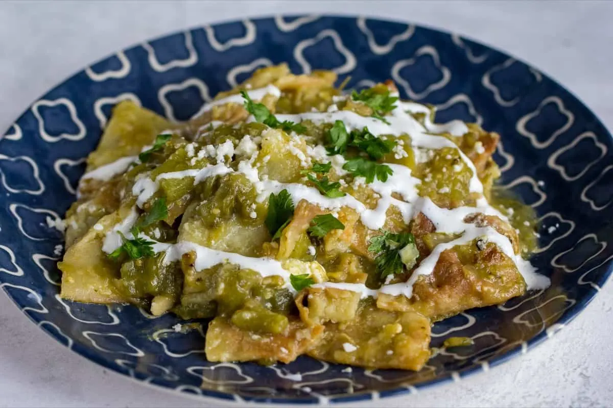 chilaquiles on a blue plate with sour cream