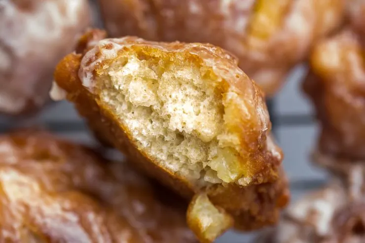 Apple Fritter with a bite taken out of it pointed up at the camera