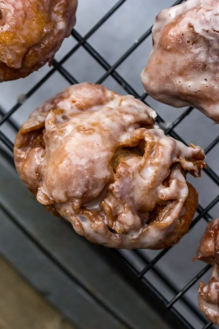 Glazed Apple Fritters on a rack