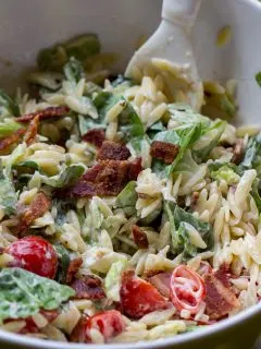 BLT Pasta Salad closeup with tomato and bacon in a large bowl