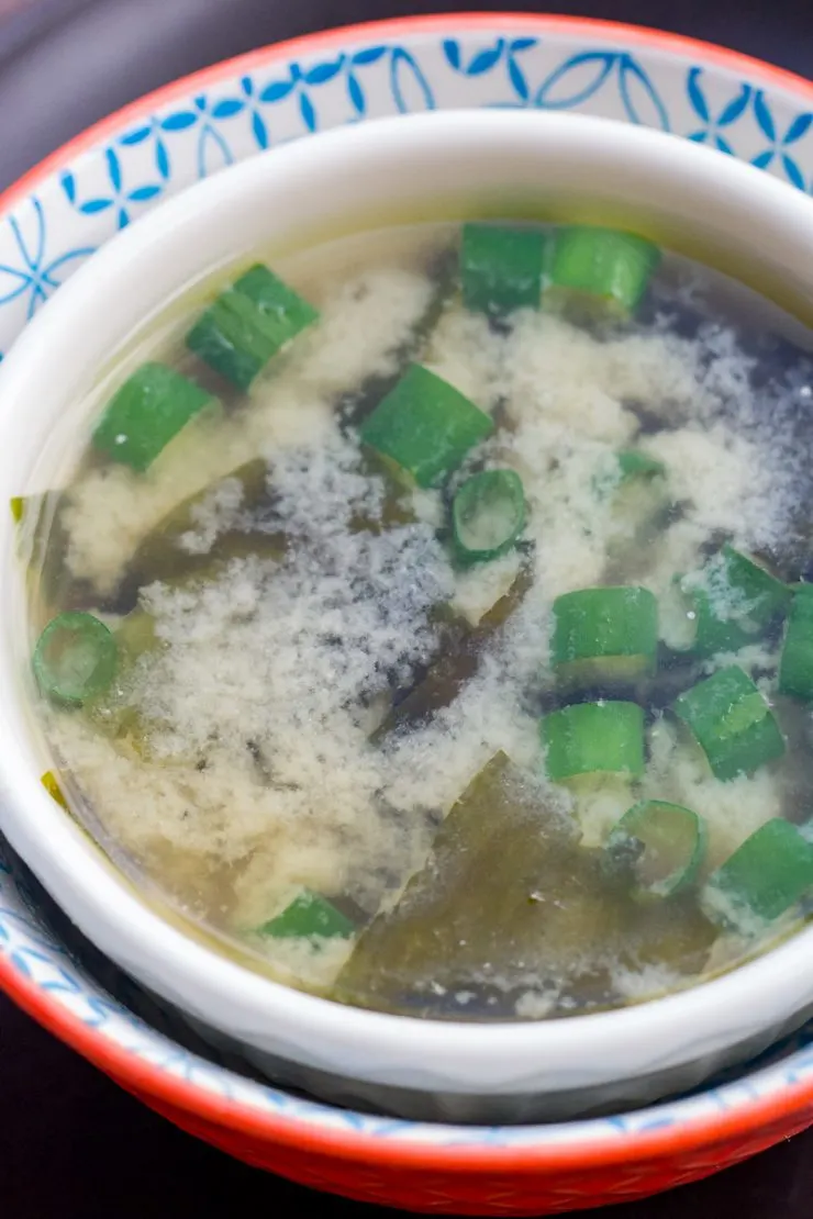 Miso Soup Recipe in a white bowl with green onions and seaweed