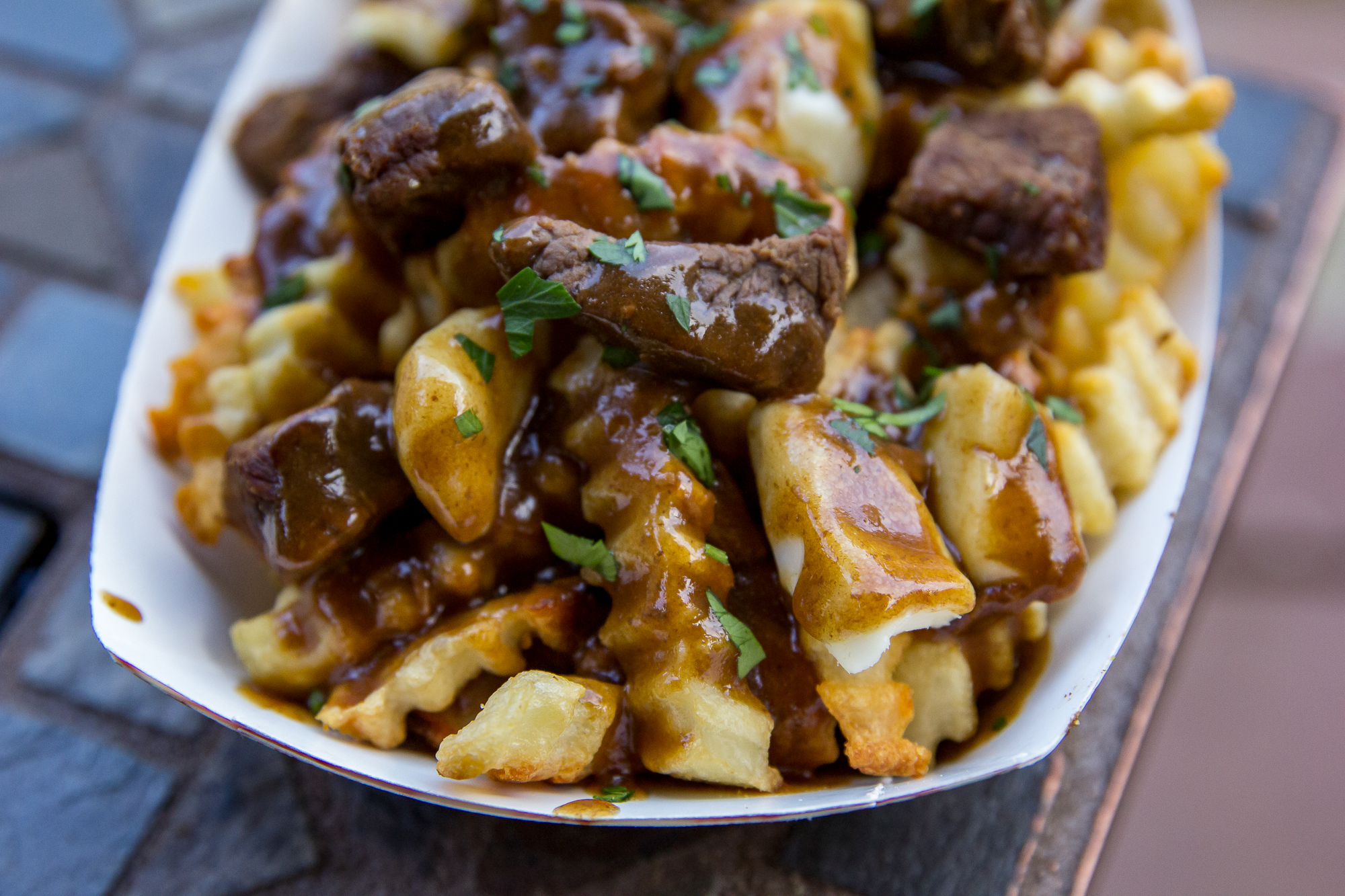 Traeger Poutine with french fries and brown gravy in a paper container