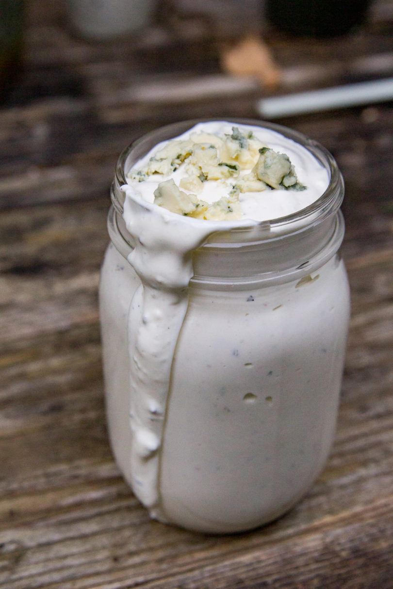 Bacon Bleu Cheese Dressing in a mason jar with some dripping down the side