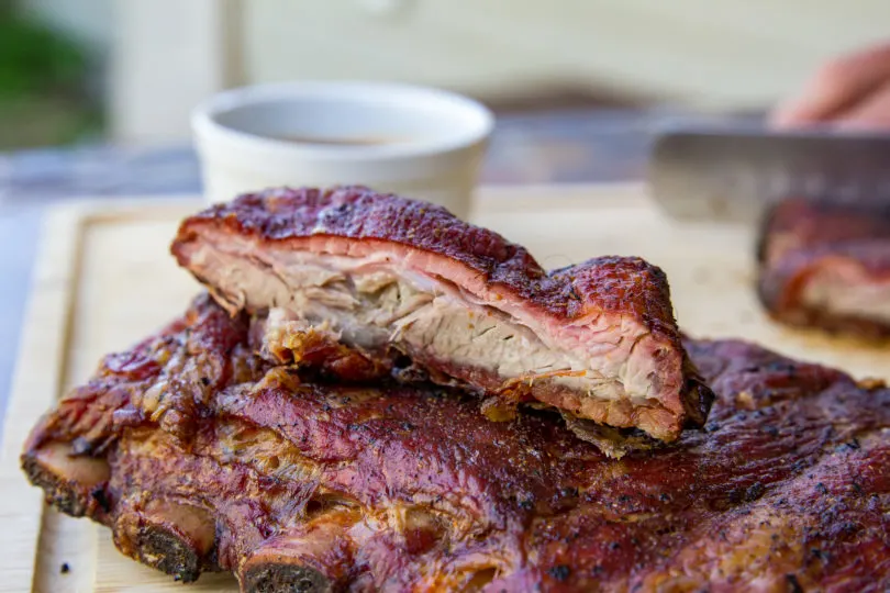 a cut St. Louis rib on top of a rack with a smoke ring