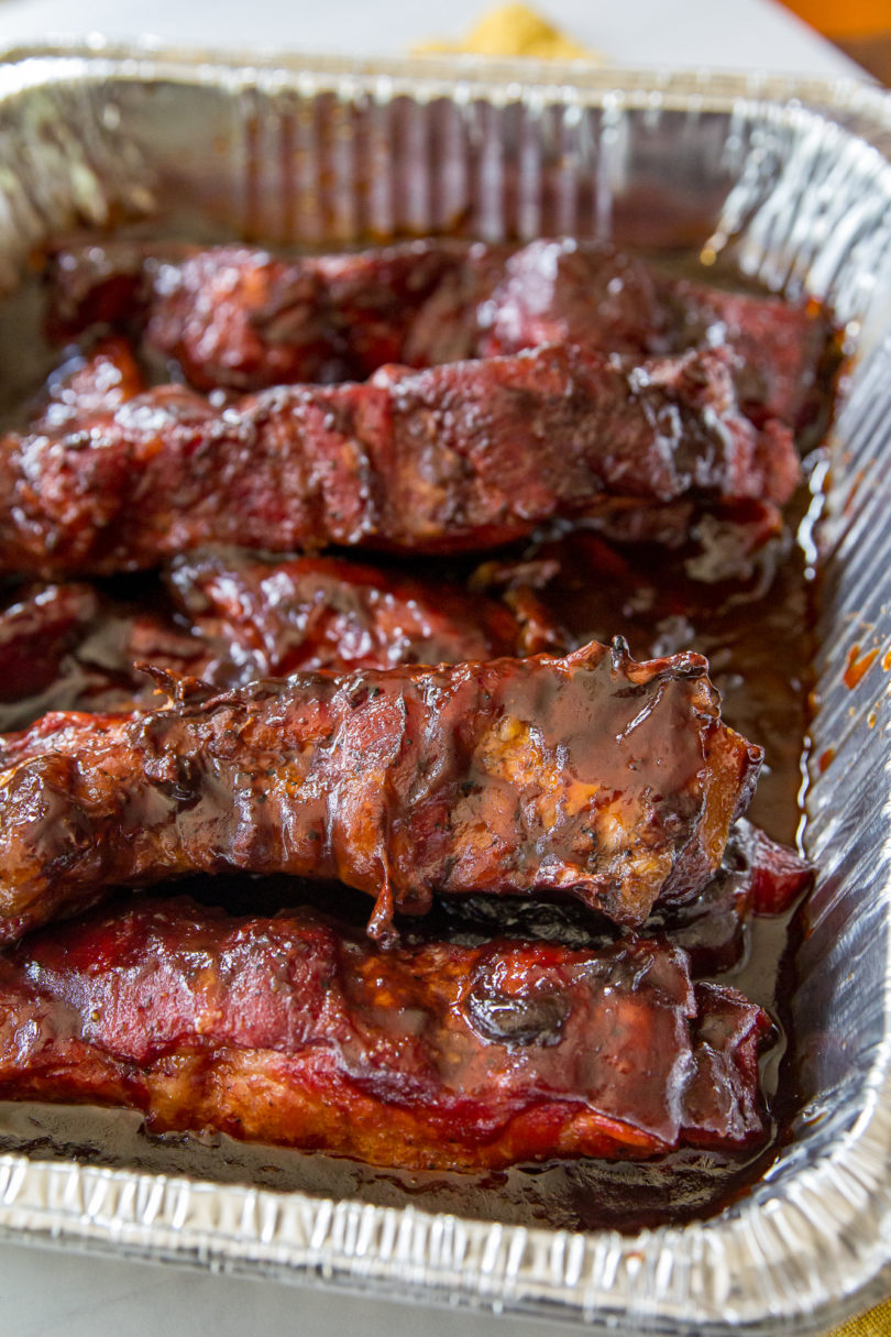 Smoked Country-Style Pork Ribs in a metal pan covered with barbecue sauce