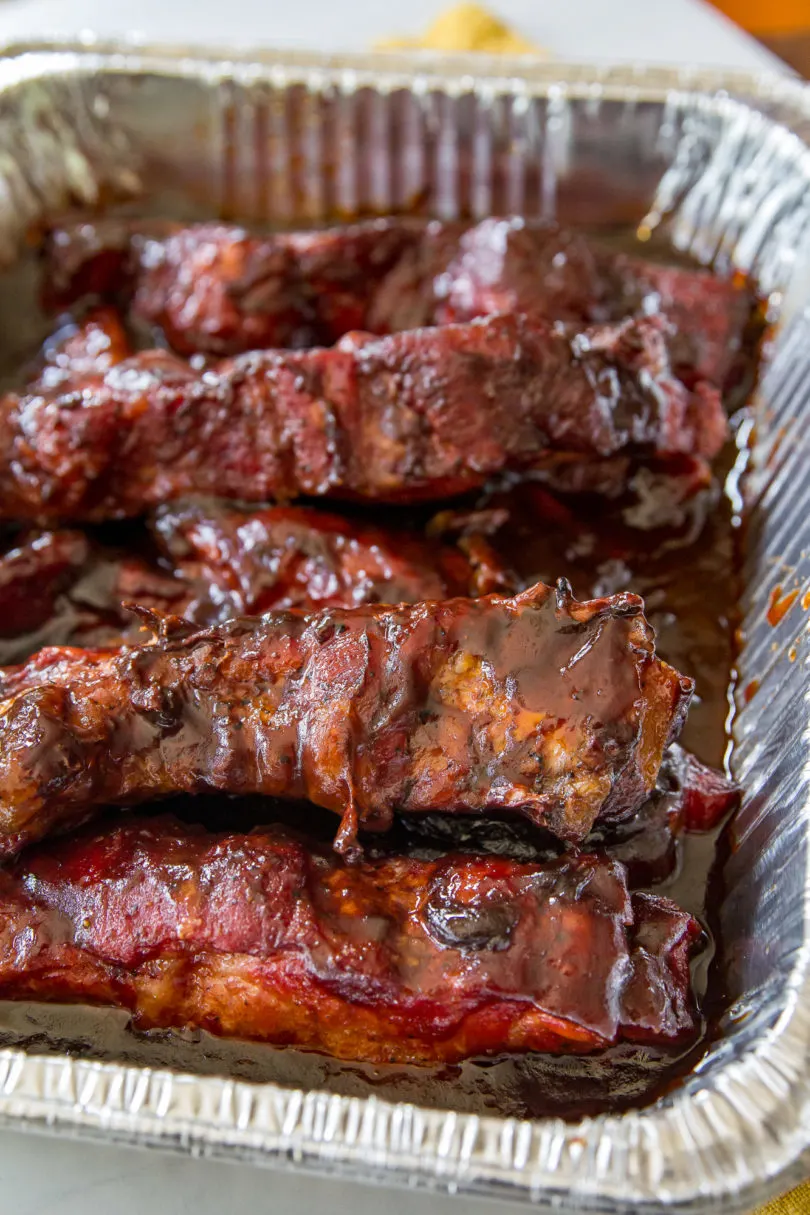 Smoked Country-Style Pork Ribs in a metal pan covered with barbecue sauce