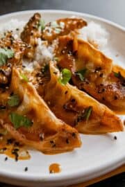 Coconut curry dumplings served with rice, garnished with cilantro and black sesame seeds.