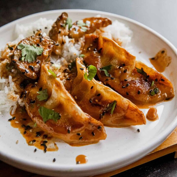 Coconut curry dumplings served with rice, garnished with cilantro and black sesame seeds.