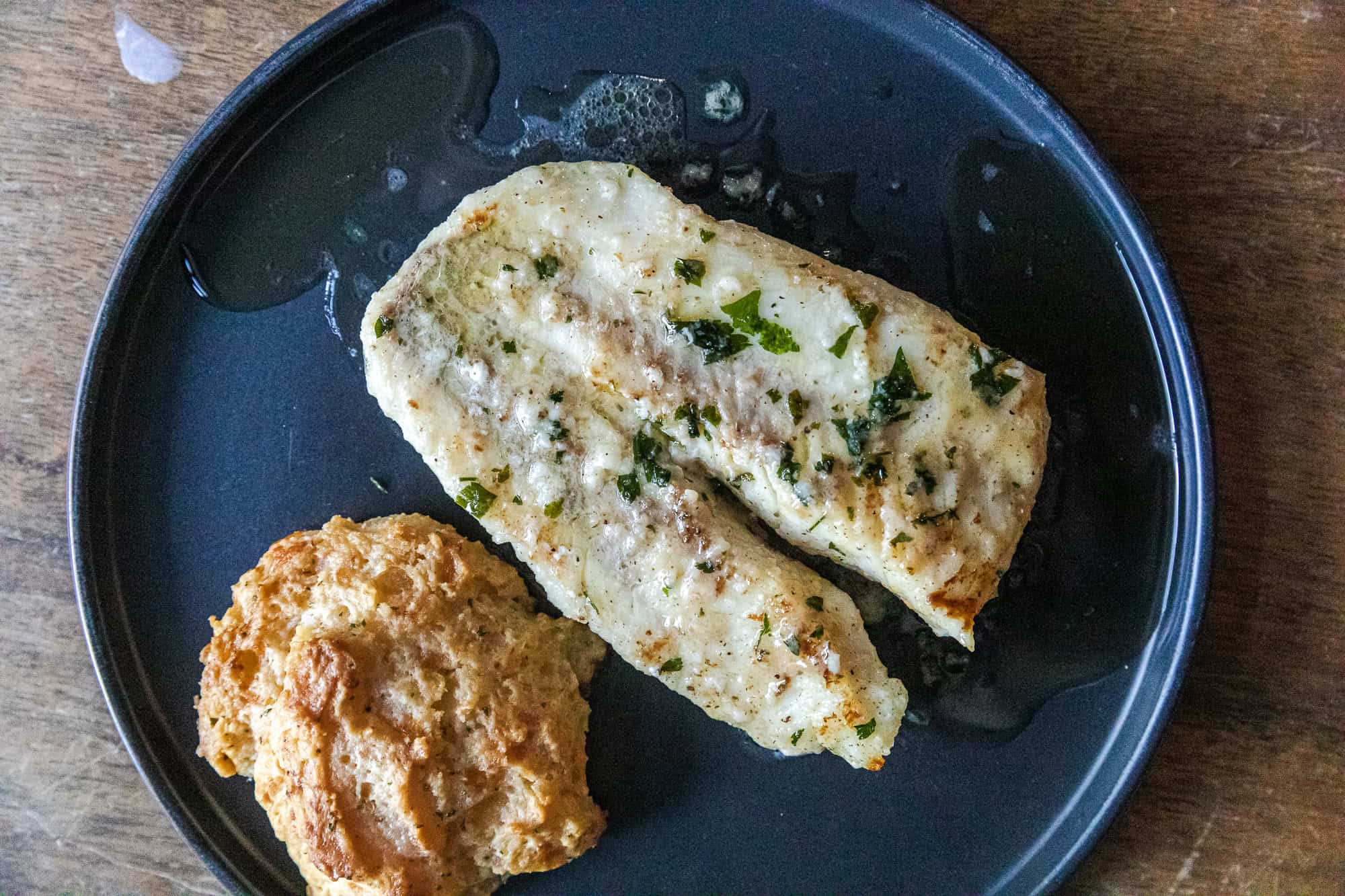 Delicious fish scampi topped with herbs served with a crispy side, perfect for seafood lovers.