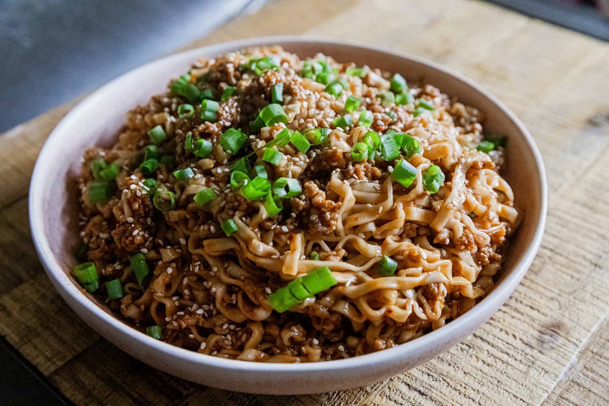 Delicious soy scallion noodles topped with savory pork and fresh green onions. Perfect for a flavorf.