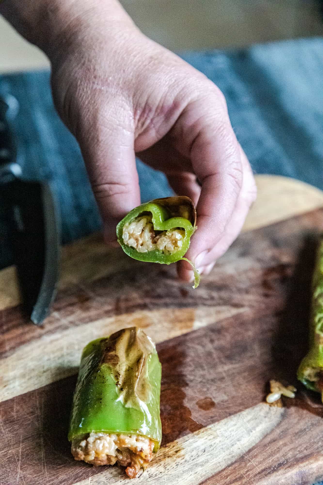 Spicy stuffed hatch chili peppers with savory filling on wooden cutting board.