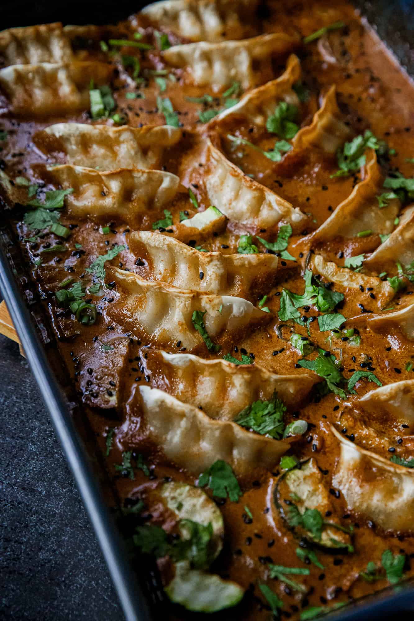 Delicious coconut curry dumplings cooked on a Traeger grill, garnished with fresh herbs. Perfect for.