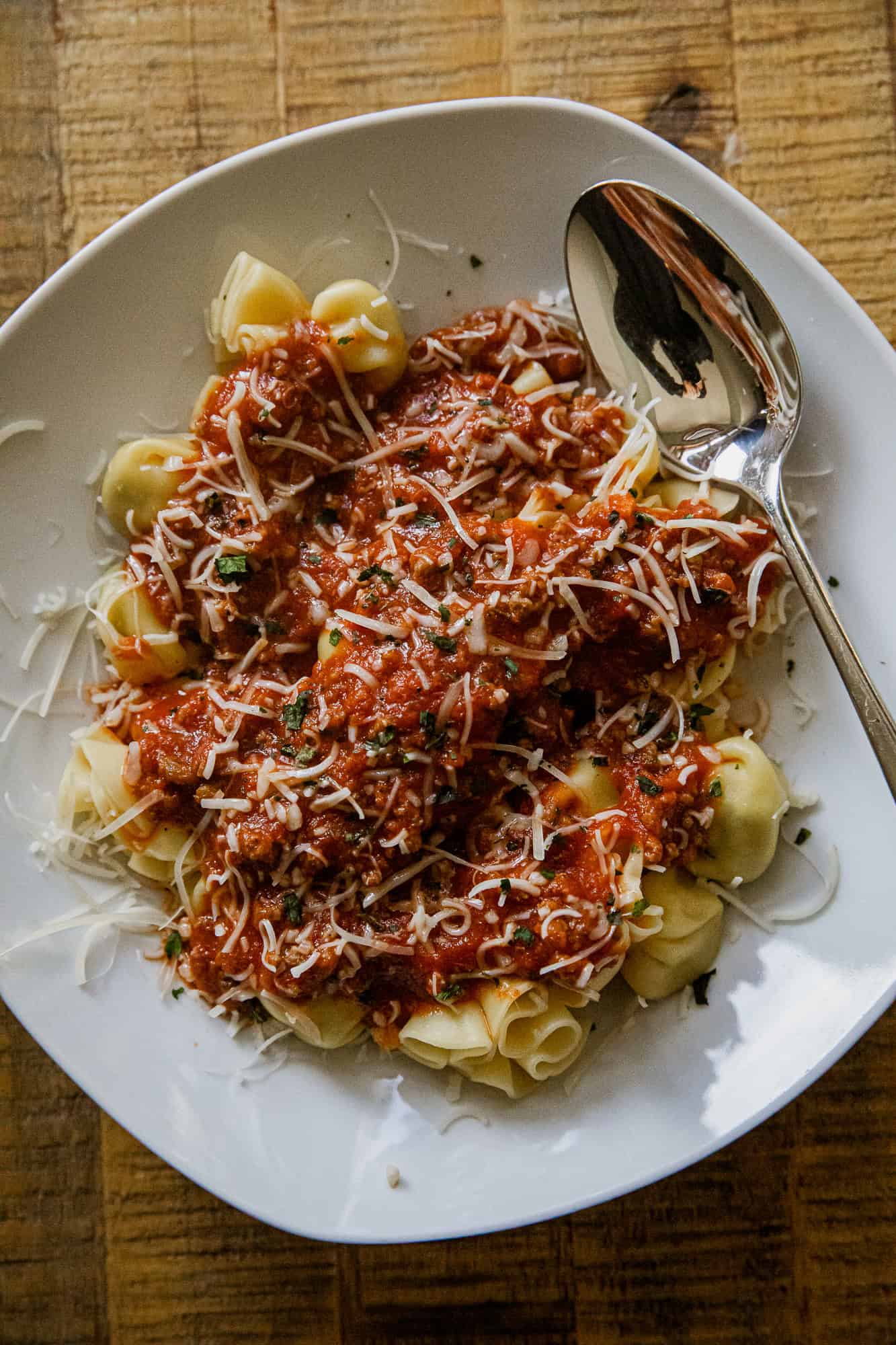 Delicious cheese tortellini topped with hearty meat sauce and sprinkled with grated cheese. Perfect.