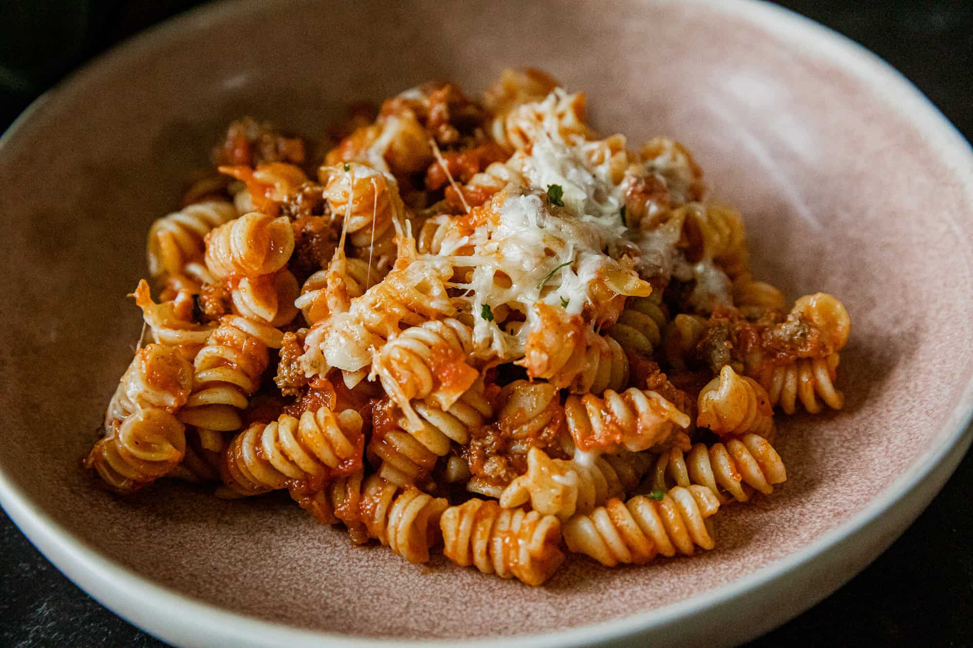 Delicious cheesy rotini pasta bake with ground meat and melted cheese.