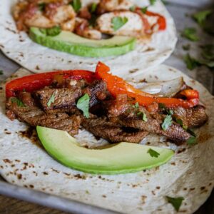 Steak fajitas with peppers and avocado on a soft tortilla, perfect for quick and flavorful meals.