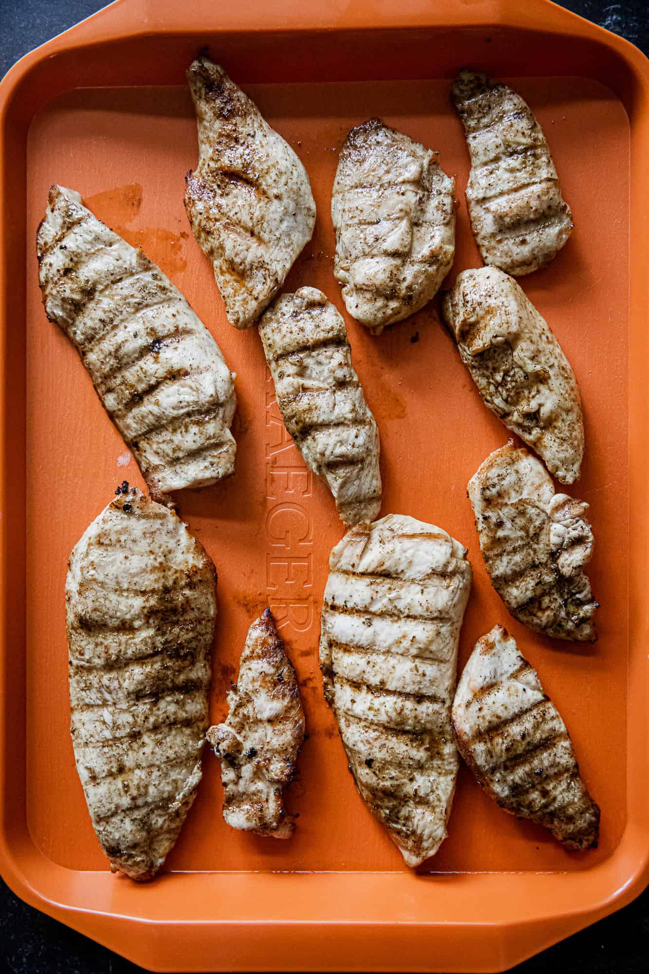 Grilled chicken breasts with grill marks, cooked to perfection on a Traeger grill. Perfect for healt.