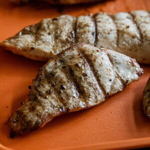 Juicy Traeger-grilled chicken breasts with grill marks and seasoning.