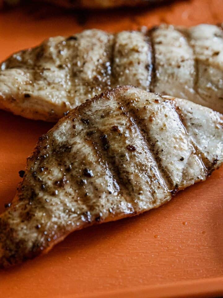 Juicy Traeger-grilled chicken breasts with grill marks and seasoning.