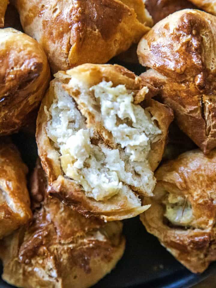 Delicious bite-sized biscuit bites filled with creamy artichoke dip, perfect for appetizers or snack.
