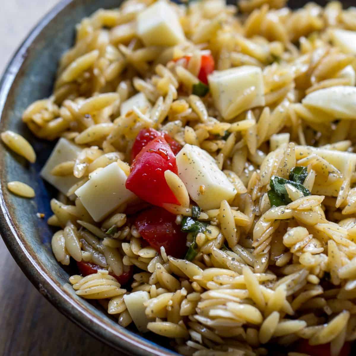 Delicious pasta salad featuring cherry tomatoes, mozzarella, and herbs, perfect for summer meals or.