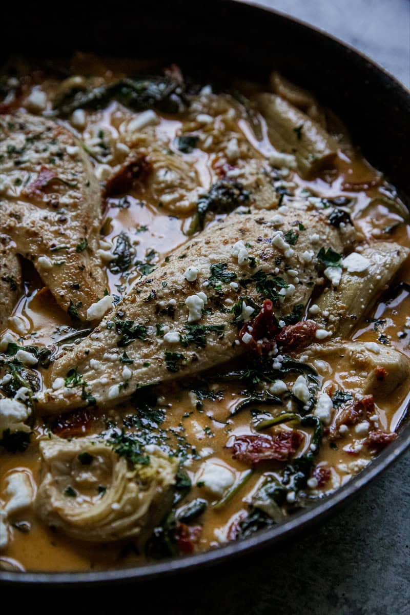 Creamy chicken and spinach skillet with herbs and cheese in a rich sauce. Perfect for a comforting,.