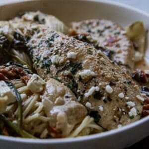 Delicious grilled fish served with vegetables and pasta in a white bowl.