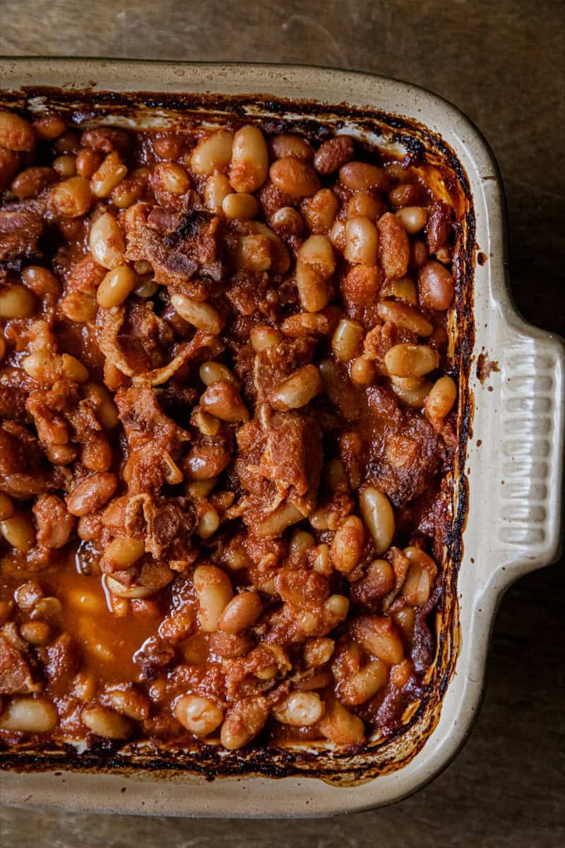 Baked bean casserole with ground meat and beans in a ceramic baking dish.