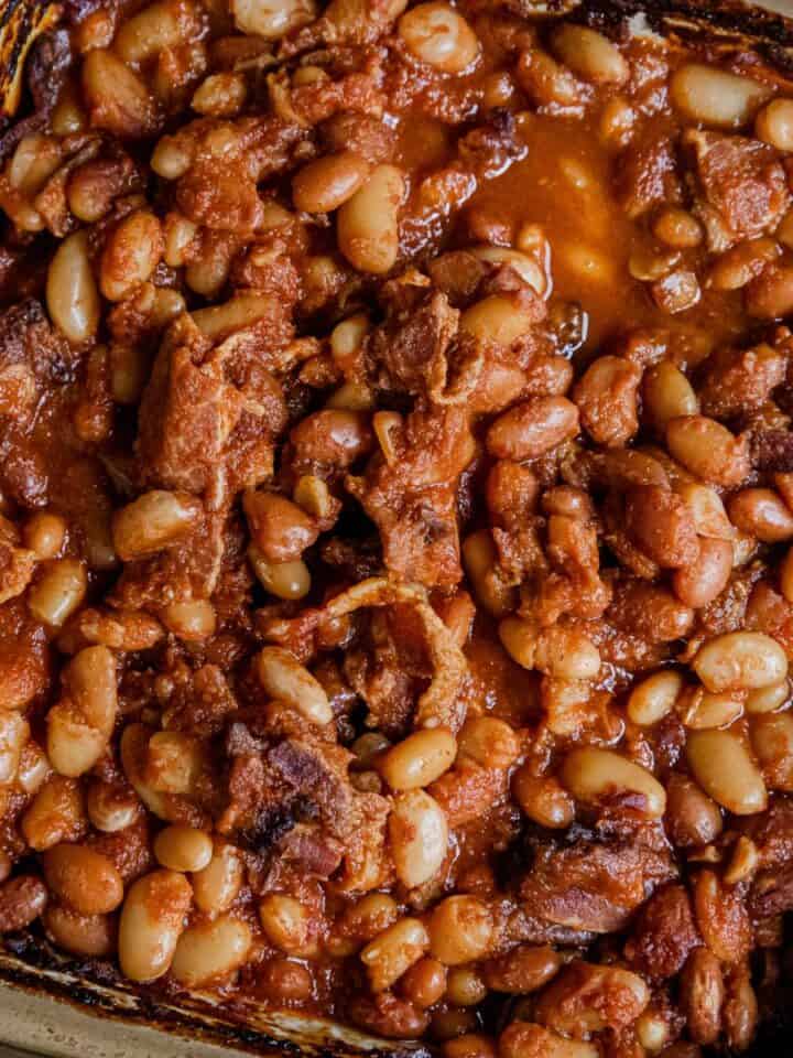 Baked beans with bacon and tomato sauce in a baking dish.