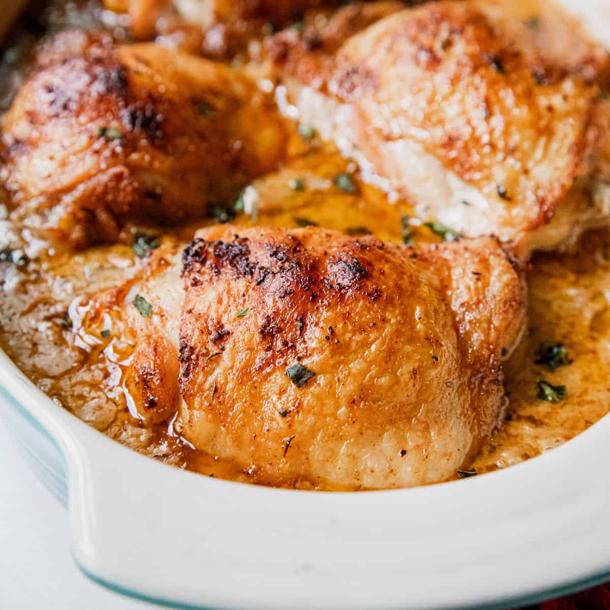 Juicy baked chicken thighs with flavorful sauce and herbs.
