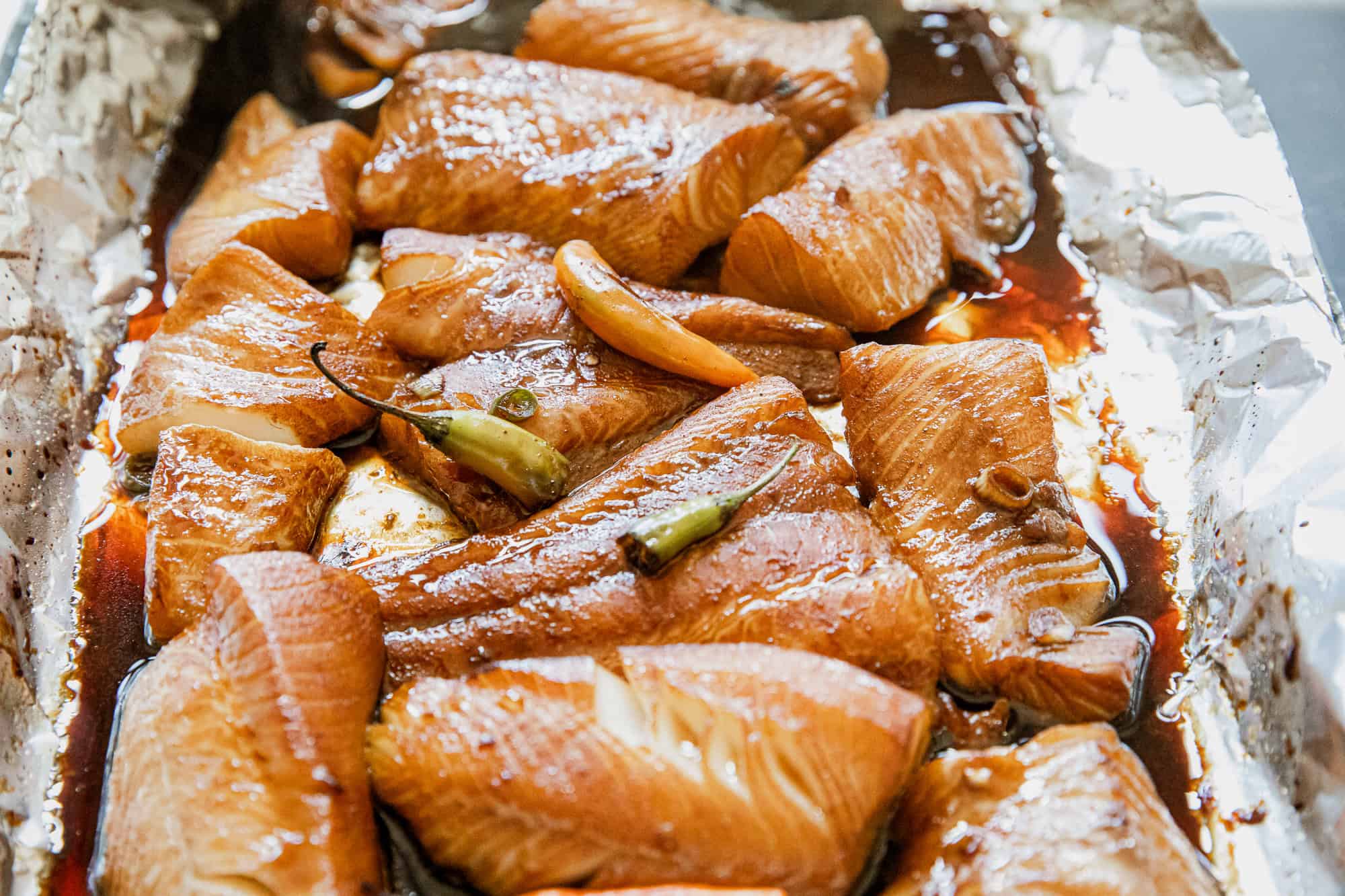 Delicious baked salmon fillets topped with garlic and green chili, cooked to perfection with a flavo.