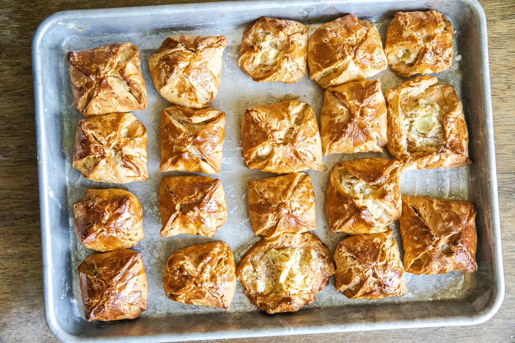 Delicious baked biscuit bites filled with artichoke dip, perfect for appetizers or parties.