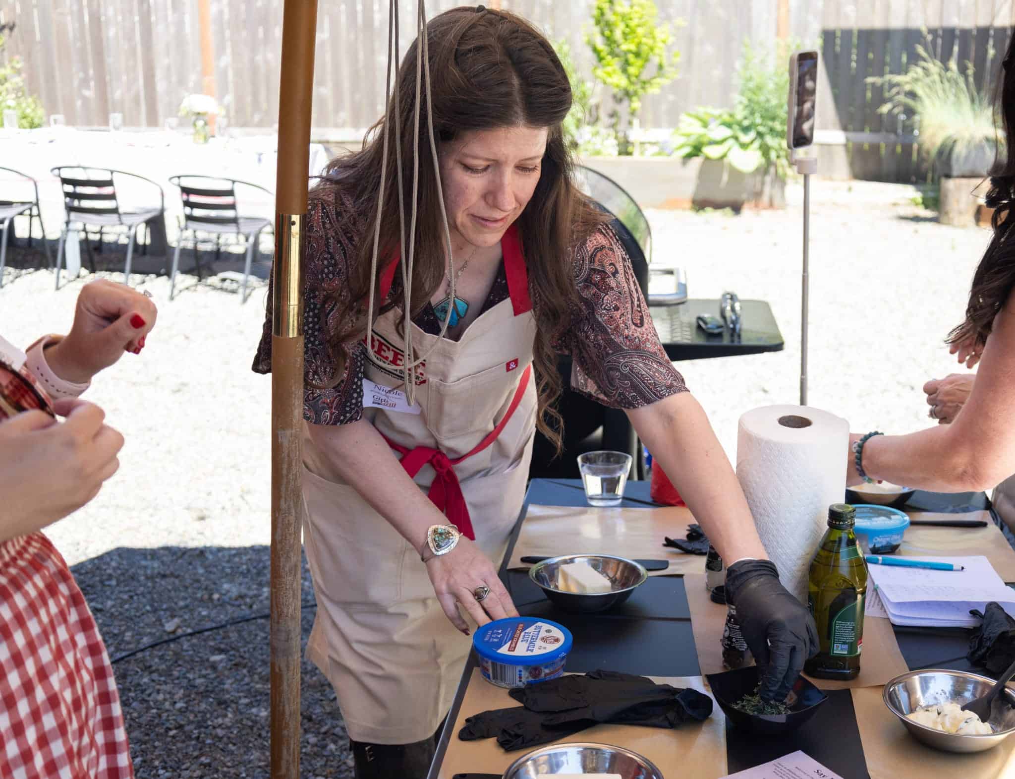 Women preparing food outdoors for a barbecue event.