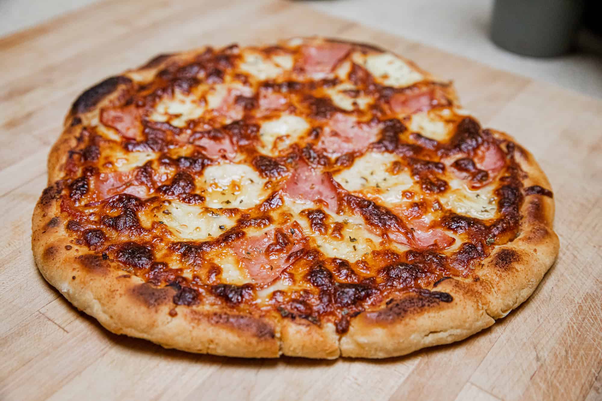 Delicious grilled Hawaiian pizza with pineapple, ham, and melted cheese.